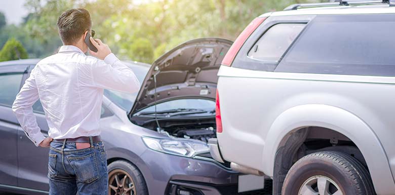 Man on phone looking at car crash