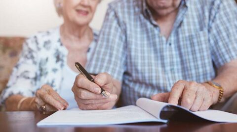 Elderly couple signing estate planning documents