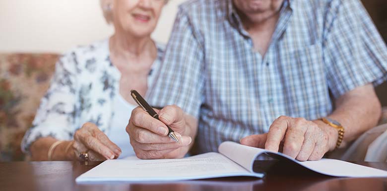 Elderly couple signing estate planning documents