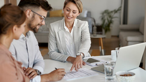 Young couple sitting at a table reviewing estate planning documents